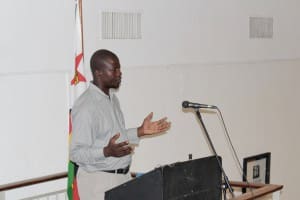 Patrick Kwambi Kabeya, poeta congoleño refugiado en Tongogara, Zimbabwe, recita en la inauguración en Harare. Fotografía de Kwenda Kumbirayi.