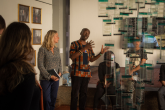 Katrin Peters-Klaphake y Raphael Chikukwa muestran la exposición a la prensa. A la derecha, la instalación de Immy Mali; al fondo, una fotografía de Miriam Syowia Kyambi. Kampala, Uganda.