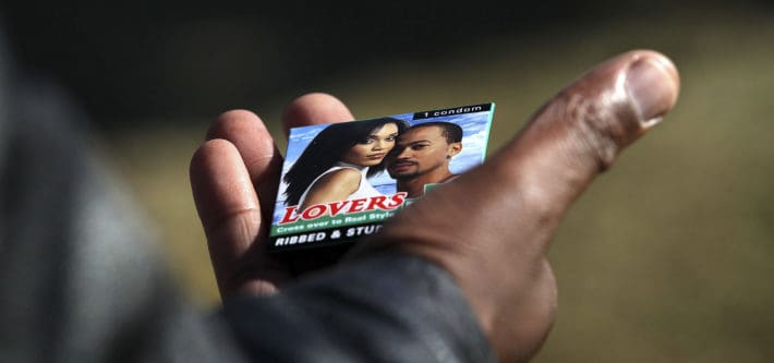 JOHANNESBURG, SOUTH AFRICA - JUNE 16: A Soweto youth holds a free condom he received at a HIV/AIDS awareness event held by the non-profit Population Services International (PSI), ahead of a World Cup game on June 16, 2010 in Soweto, Johannesburg, South Africa. South Africa has the highest number of people living with HIV in the world, where almost one-third of women between the ages of 25-29 are HIV positive. (Photo by John Moore/Getty Images)