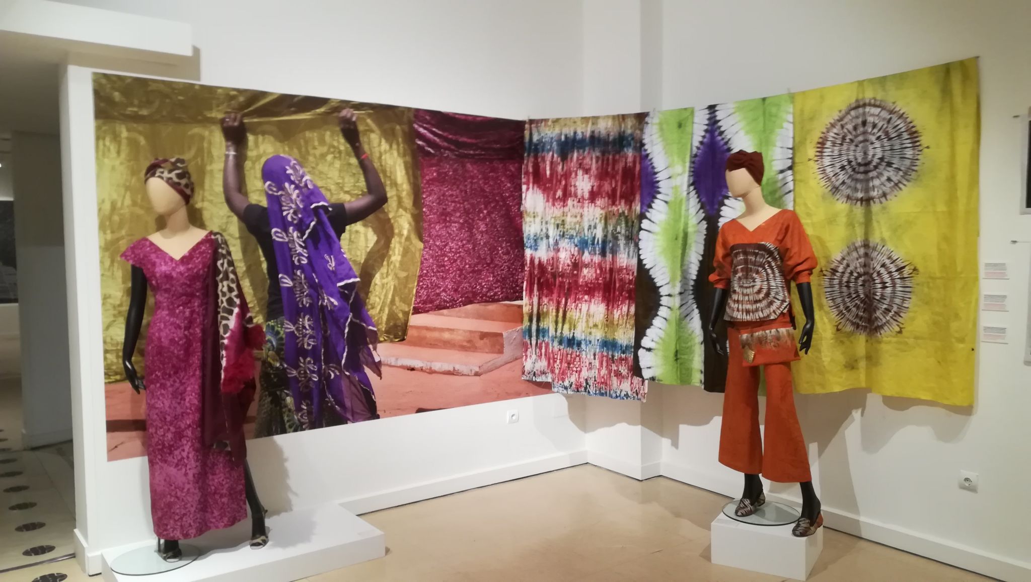 Sala de la exposición “El lenguaje de las telas. Arte textil en África Occidental, Ghana, Malí y Costa de Marfil” con fotografías de Kim Manresa y tejidos batik y otras técnicas.