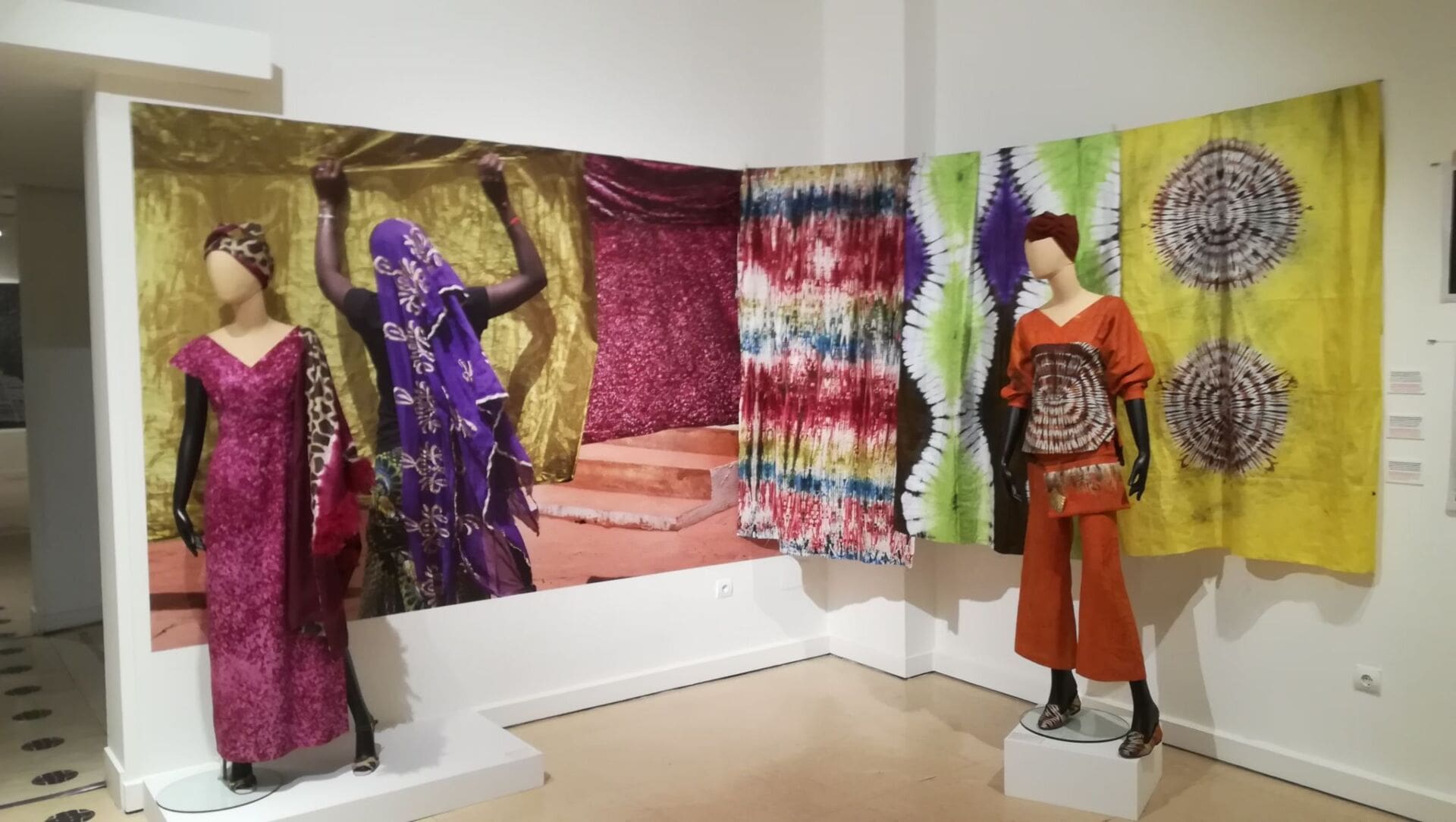 Sala de la exposición “El lenguaje de las telas. Arte textil en África Occidental, Ghana, Malí y Costa de Marfil” con fotografías de Kim Manresa y tejidos batik y otras técnicas.